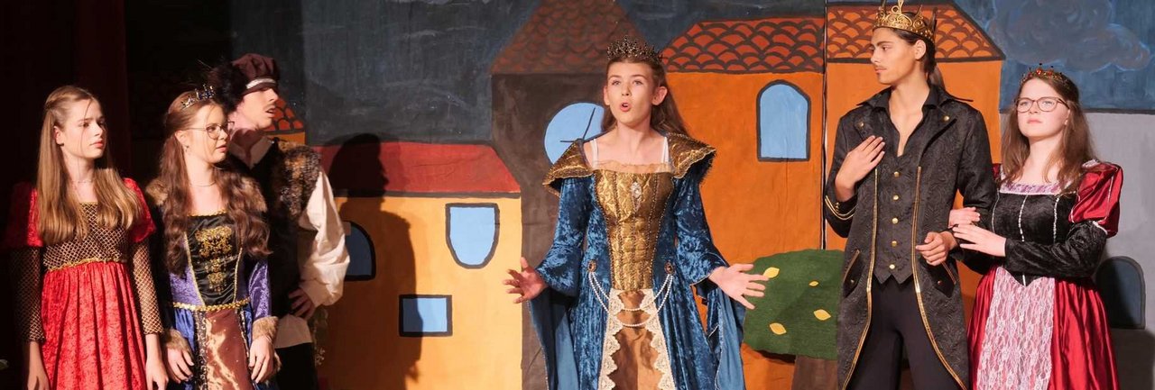 Schülerinnen und Schüler der Theater-AG präsentieren das Theaterstück auf der Bühne.
