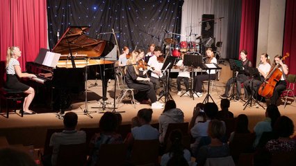 Musiker spielen auf der Bühne Lieder vor.